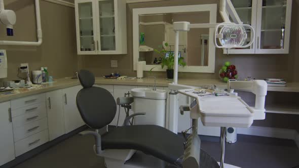 Empty interior of dental clinic with black dental chair and tools