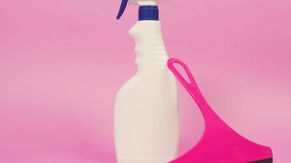 A White Spray Bottle with Household Chemicals and a Window Cleaning Scraper