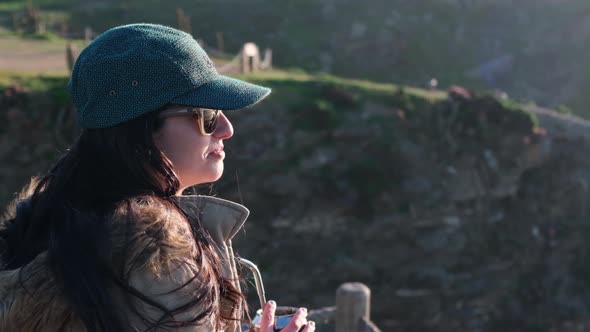 woman drinking yerba mate, typical Argentine drink, on the beach, while watching the sunset