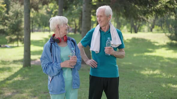 Front View Portrait of Happy Senior Couple Gesturing Thumbs Up Smiling Looking at Camera Standing