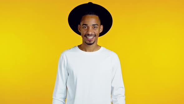 Portrait of Smiling African American Handsome Man in Black Hat Looking To Camera. Guy in Studio on