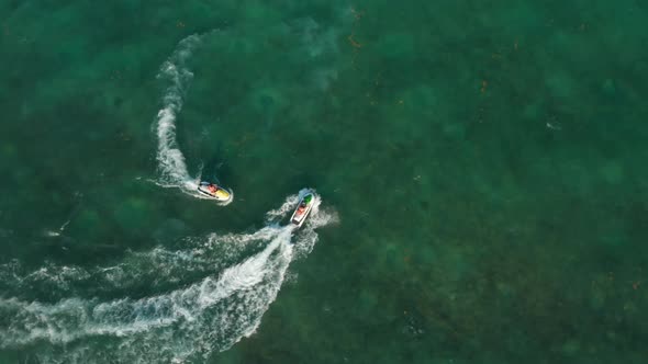 Jet Ski Riders Enjoying Their Time While Cruising on the Calm Sea Surface