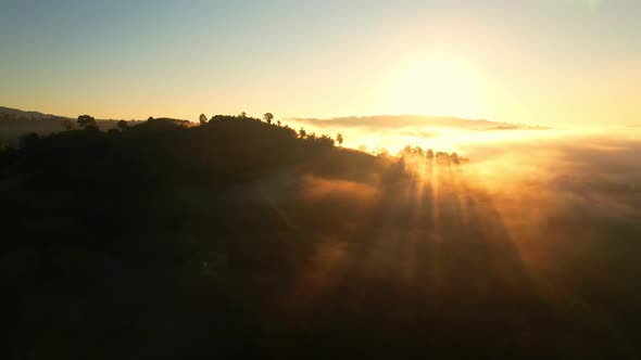 4K Aerial view from drone over mountains and sea of fog. Golden scenery at sunrise