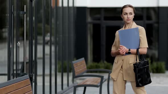 Portrait of an young successful businesswoman is smiling satisfied with her work in camera 