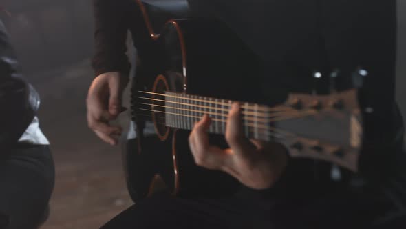 Man in a Black Sweatshirt Plays the Acoustic Guitar