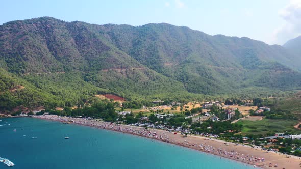 aerial view of the dry mountainous landscape of Adrasan beach in Turkey on a hot summer day as peopl