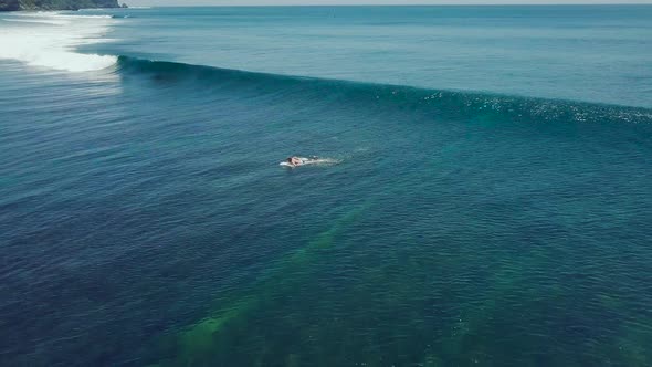 Amazing Aerial Shot of a Professional Surfer Riding a Seamless Barreling Waves.