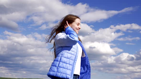 Happy Child in Autumn Jacket Posing on Sky Background Hair