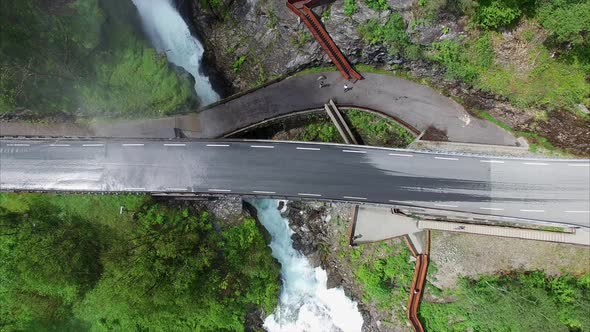 Top-down view of Svandalsfossen waterfall passing below the road in Norway