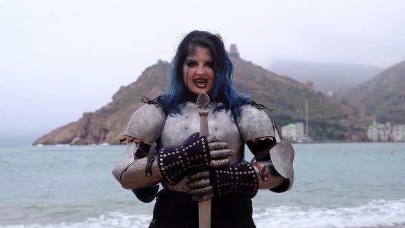 Woman Warrior in Armor Against Fortress on Rock and Sea