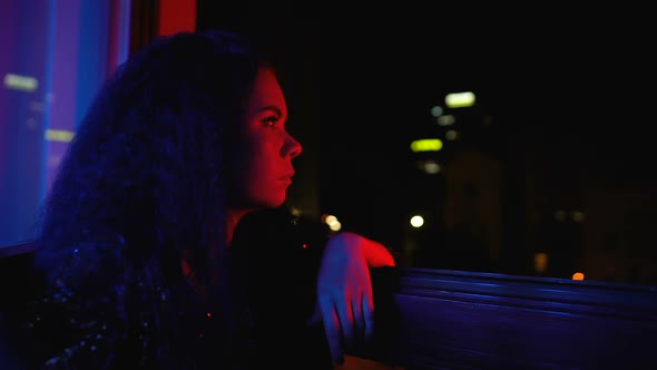 Bored Trendy Woman Sitting Alone Near Window, Uninteresting in Private Party