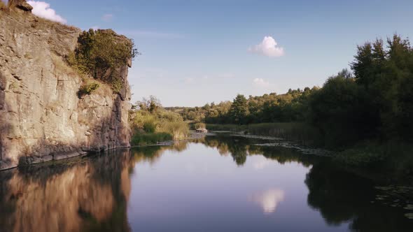 Aerial Shot with Drone Flying Close to the Water in Canyon During Sunny Day