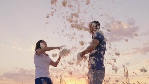 Young Couple Having Fun Playing with Feathers