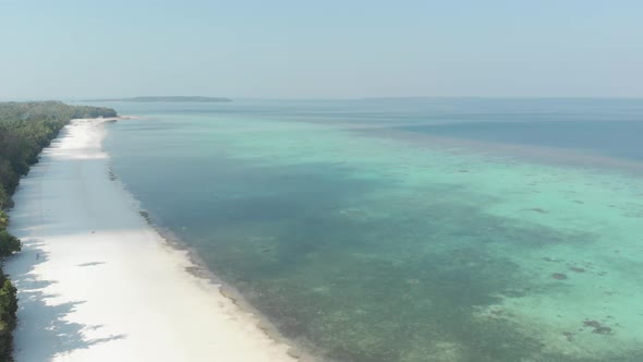 Aerial: flying over desert tropical beach in the Moluccas archipelago, Indonesia