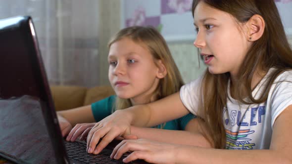 Little Girls Surfing Internet Together on Laptop