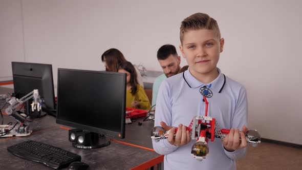 Schoolboy with a Robot That He Himself Assembled in Robotics Lessons at School