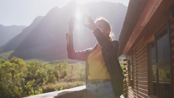 Caucasian woman taking a picture of the landscape.