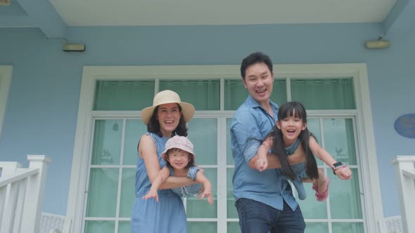 Asian happy family, Father and mother holding children play airplane flying outdoor in garden.