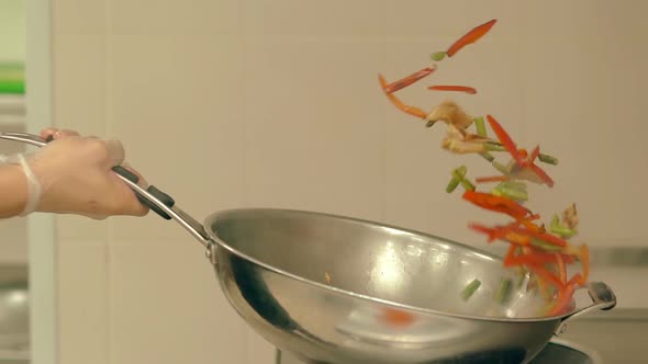 Cook Prepares Fresh Vegetables in a Frying Pan Tosses Them To Mix