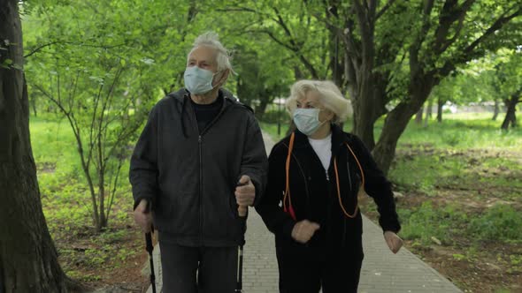 Active Senior Old Man, Woman Training Nordic Walking in Park During Quarantine alt
