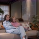 Happy young woman sitting on cozy couch with adorable little cute daughter. - VideoHive Item for Sale