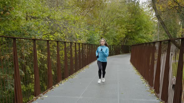 Female Jogger Running on Bridge in Park