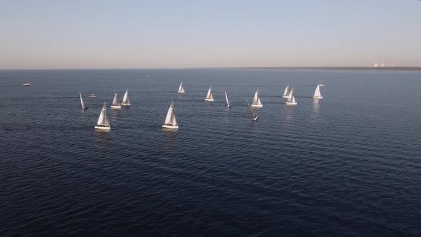 Sailing Yachts Lined Up in the Sea During a Sailing Regatta and Cast Shadows