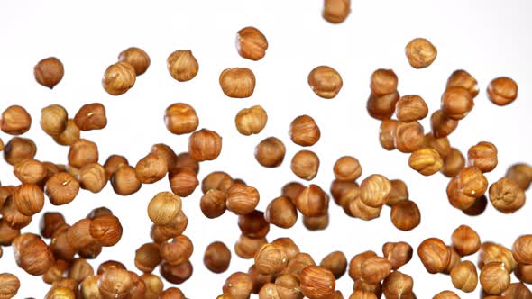 Super Slow Motion Shot of Flying Hazelnuts After Being Exploded on White Background at 1000 Fps.