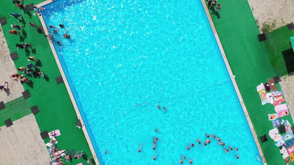 Flight Over the Blue Pool with People on Vacation. Aerial View on Clean Swimming Pool