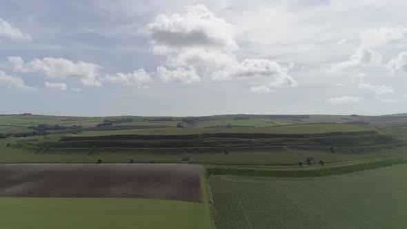 Aerial tracking back centring on the grand iron age hill fort, Maiden Castle. Dorchester, Dorset. Am