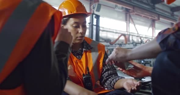 Female Engineer Talking with Factory Workers