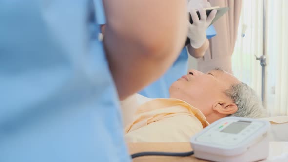 Asian medical team doctors nurse examining and checking Asian elderly male patient