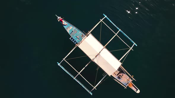 Drone Rising Above Woman Sunbathing On Outrigger Boat