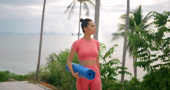 Brunette Sport Woman Walking From the Outdoors Gym She Dressed in Sports Wear and Carry a Blue Mat