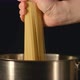 A cook puts down a bunch of spaghetti in a steel pot - VideoHive Item for Sale