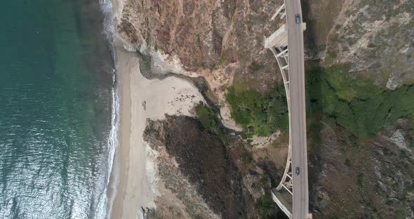 Aerial Drone Stock Video of Bixby Bridge Highway with water and shore below in Big Sur Monterrey Cal