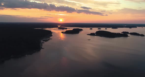 Aerial shot at sunset over lake with islands. Slow, descending aerial shot.