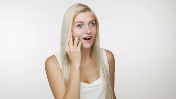 Bright Blond Girl Having Pleasant Mobile Conversation Holding Smartphone in Hand Smiling at Camera