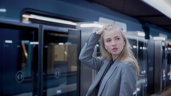 Business Blonde with Long Hair Girl Waiting for Metro Train Arriving Behind Her