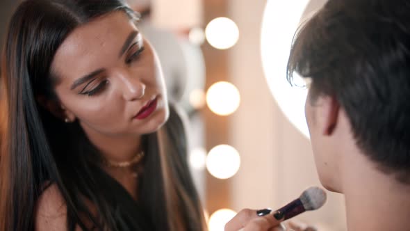 Make Up Artist Applying Powder on the Face of Male Model Using a Fluffy Brush