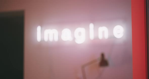 Blurry neon sign imagine with a young woman walking into the frame in vr goggles