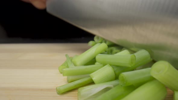 Green Onion are Cut with Knife in Kitchen