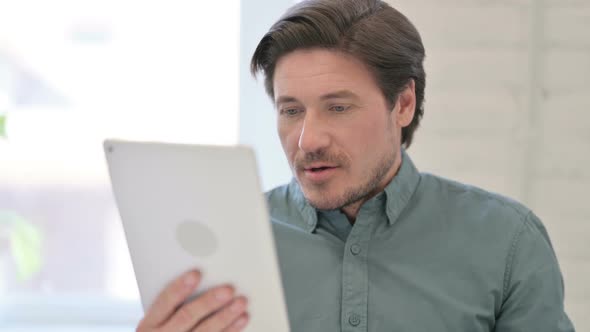 Portrait of Middle Aged Man Celebrating Success on Tablet