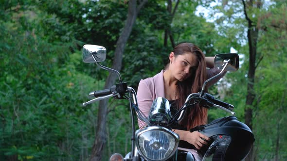 Beautiful Woman On A Motorcycle Takes Off Her Helmet And look In The Mirror