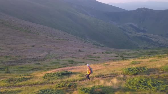 Tourist Hiker with a Backpack Running on Mountain Path in Carpathian Mountains