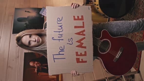 Female Guitarist Holding Future Is Female Sign