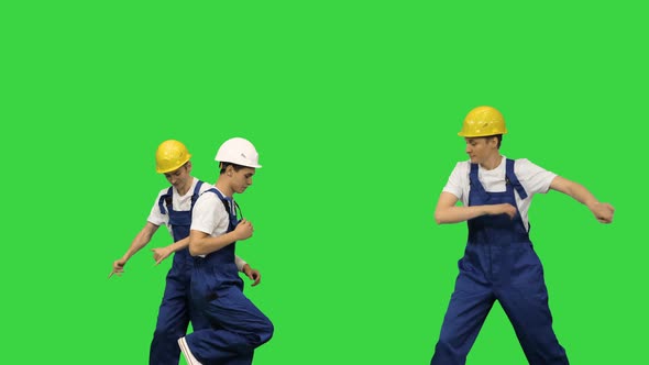 Three Male Construction Workers in Hard Hats Dancing in Free Style Passing One By One Before the