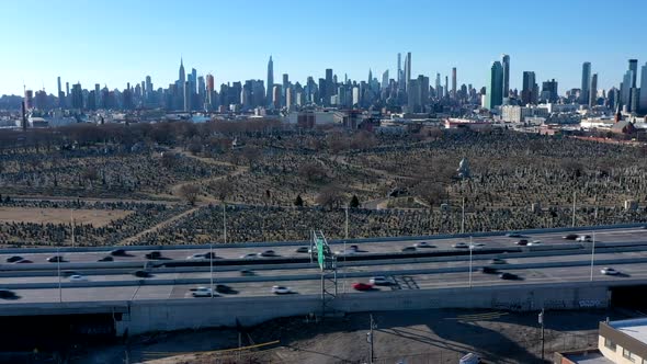 An aerial time lapse over warehouses by a highway. It was taken on a sunny day. The camera truck lef