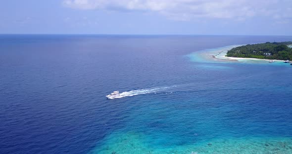 Wide angle flying copy space shot of a white paradise beach and blue water background in hi res 4K