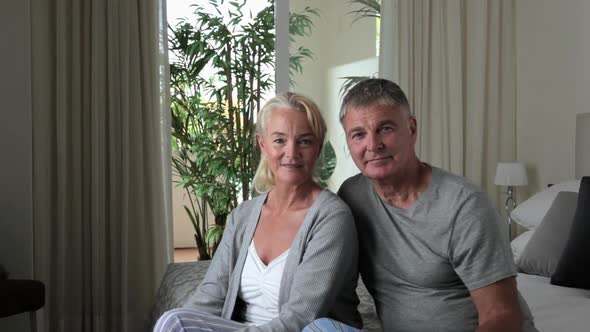 Mature couple sitting on bed